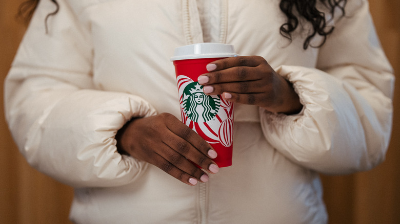 A person holding the 2024 Red Cup Day cup