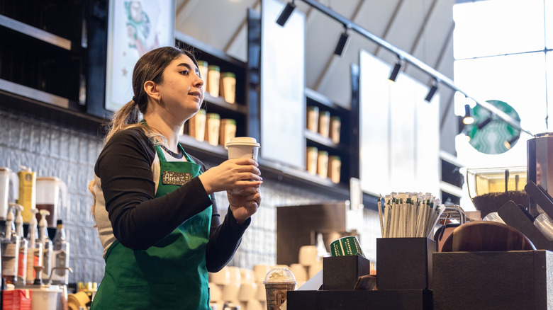 Starbucks barista holding cup