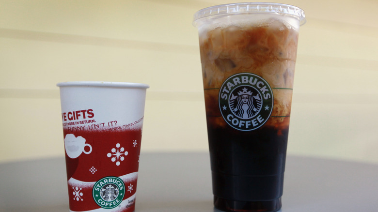 Starbucks trenta cup next to a tall cup