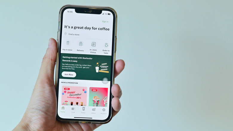 Hand holding phone with Starbucks app