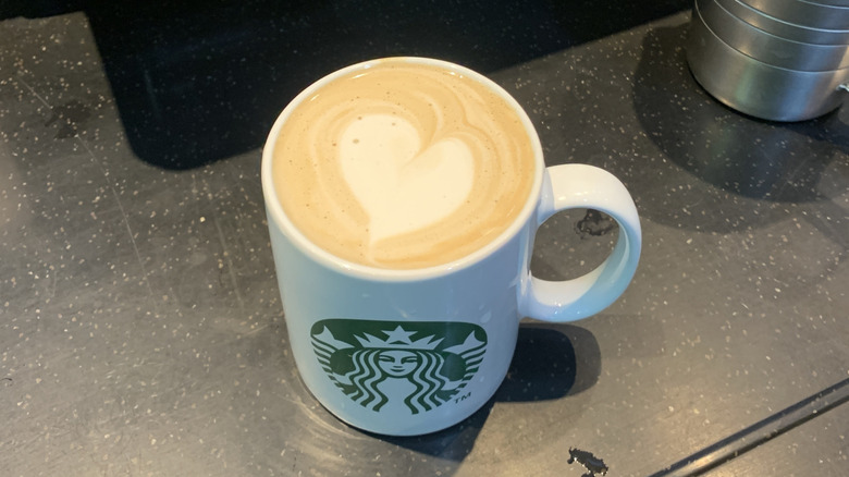 Full Starbucks mug with heart-shaped latte art.