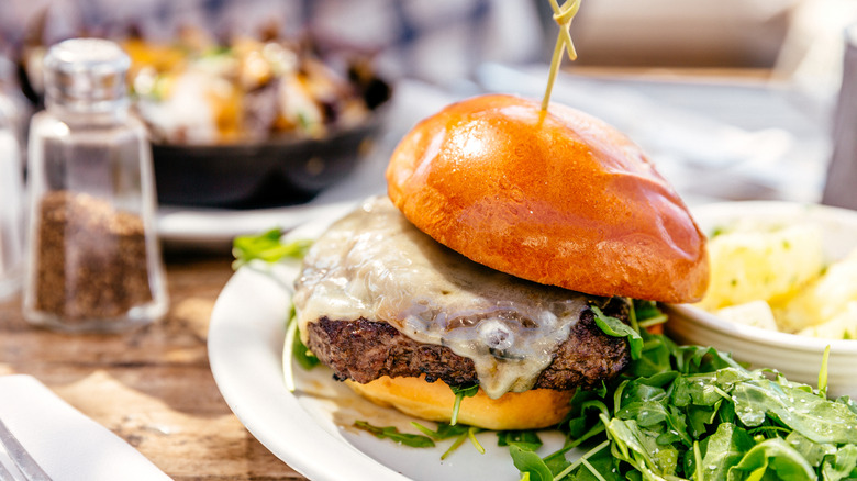 A cheeseburger, served with salad