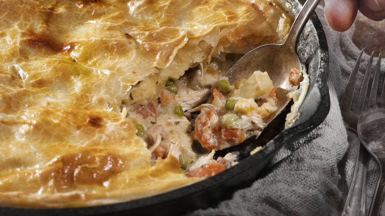 a spoon digging into a chicken pot pie