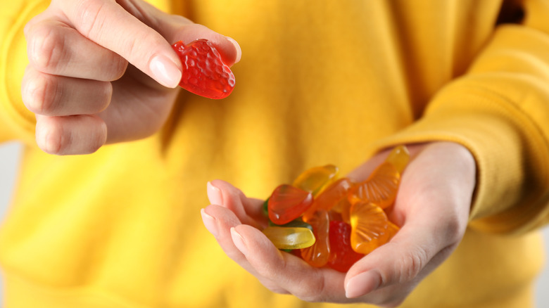 person holding fruit shaped gummy snacks