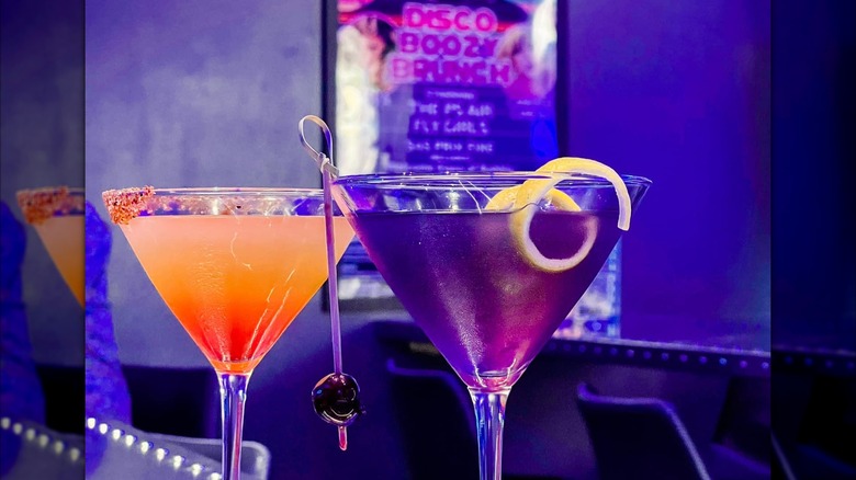 Two colorful cocktails in martini glasses on a counter in the Palm Springs Air Bar