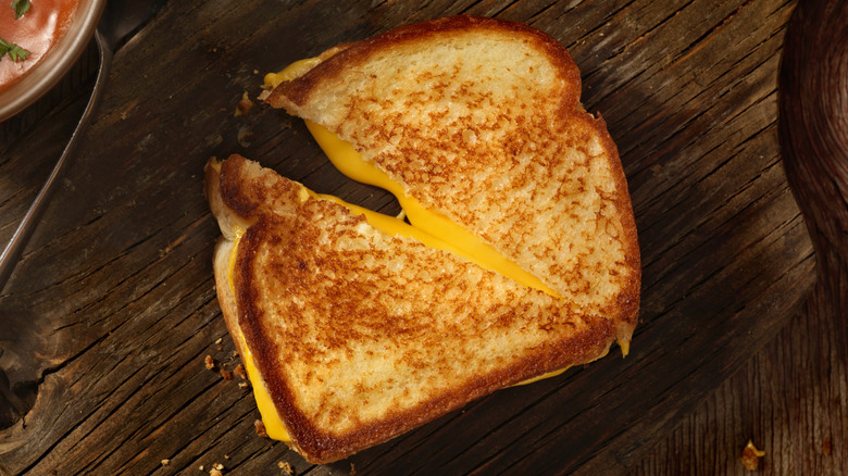 Grilled cheese cut in half on wooden background