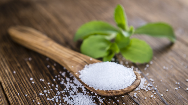 Stevia granules and leaves on wooden table
