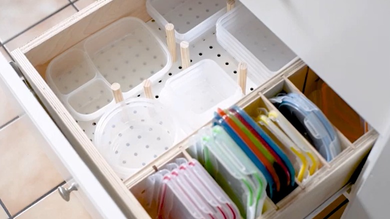 Drawer with a pegboard insert and plastic containers and lids