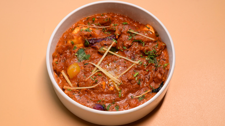 A bowl full of spicy Indian curry on a table