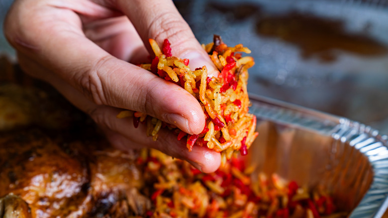 A person picking up biryani with their hand