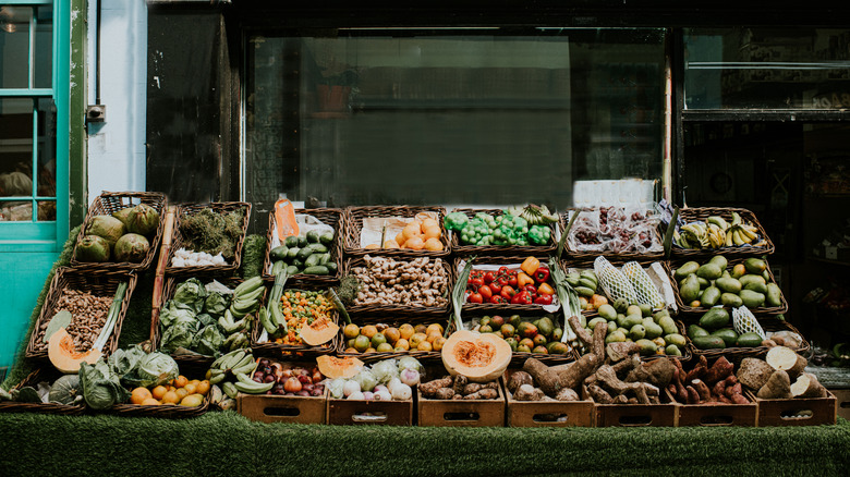 A produce stand set up in front of a shop