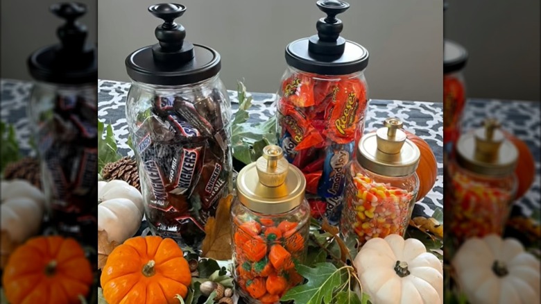 Pickle jars filled with various candies and topped with black and gold customized lids
