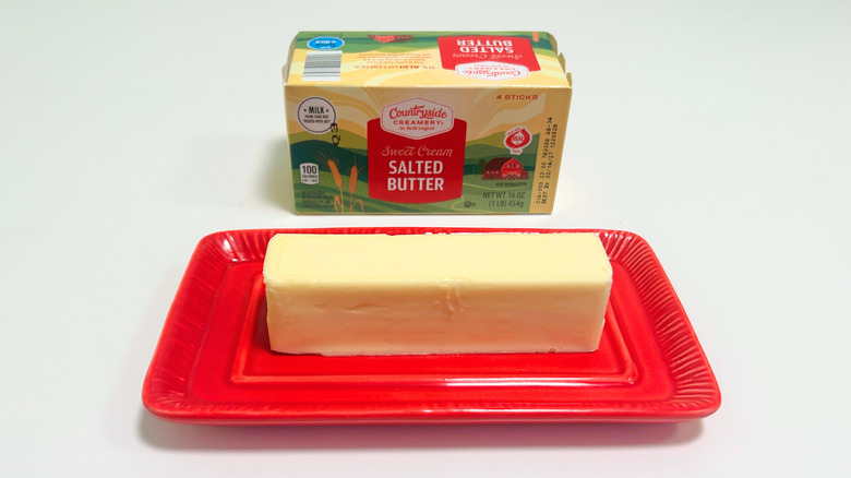A box of Countryside Creamery Sweet Cream Salted Butter next to a stick of butter on a red dish