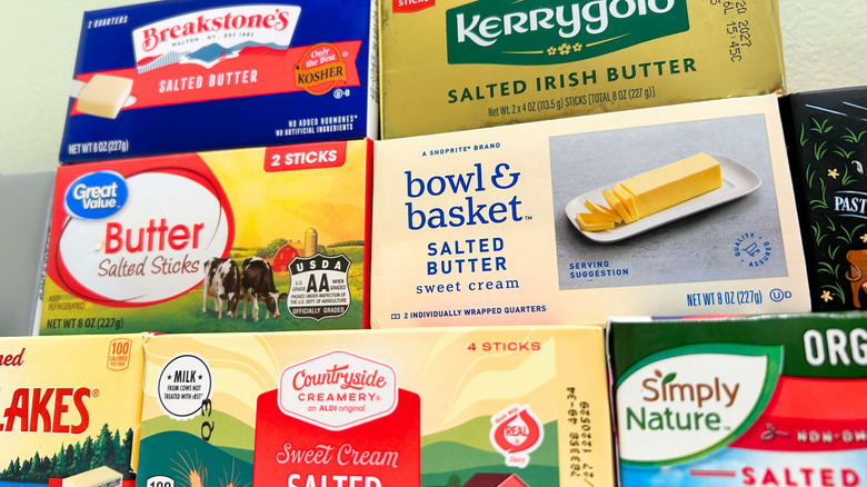 Close up of several salted butter brands stacked together