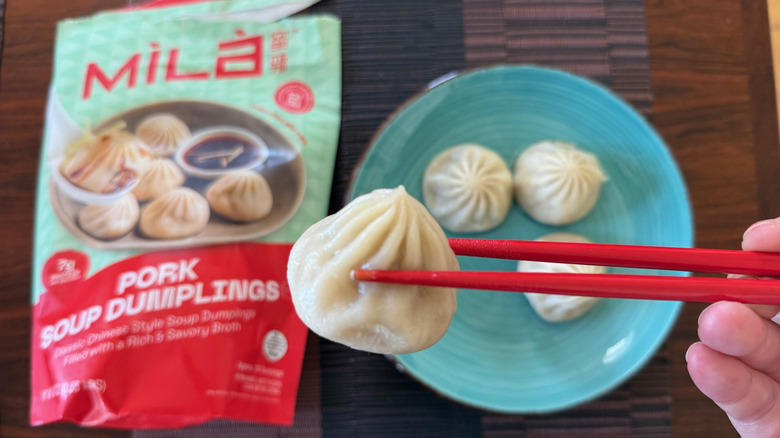Chopsticks holding a MiLa soup dumpling