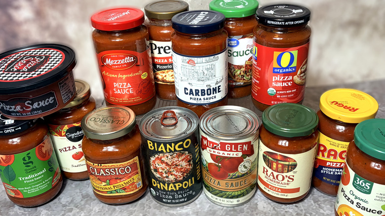 A selection of jars and cans of pizza sauces