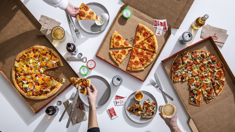 Hands taking pizza slices