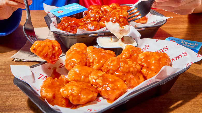 Two people eating Zaxby's boneless wings