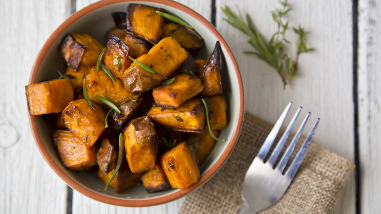roasted glazed sweet potato cubes in a bowl with fork