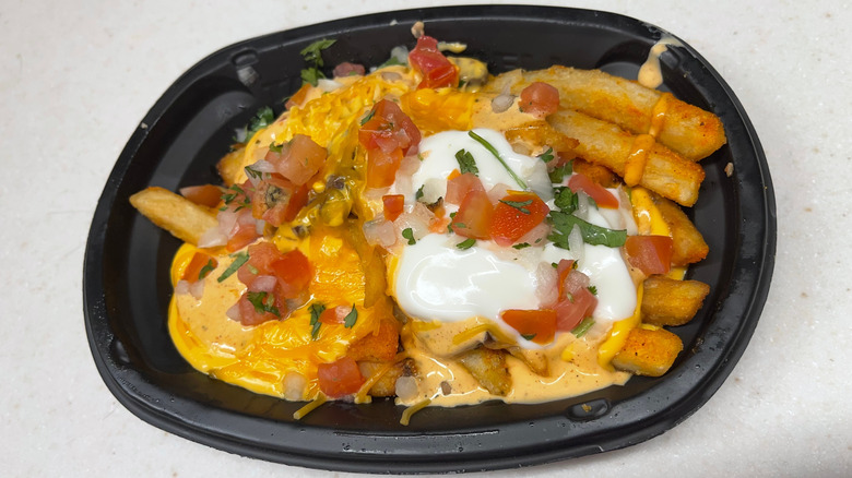 An order of Taco Bell nacho fries loaded with sour cream, pico de gallo, and cheese sauce