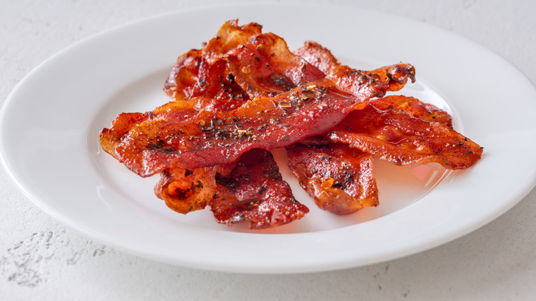 Crispy bacon strips on a white plate