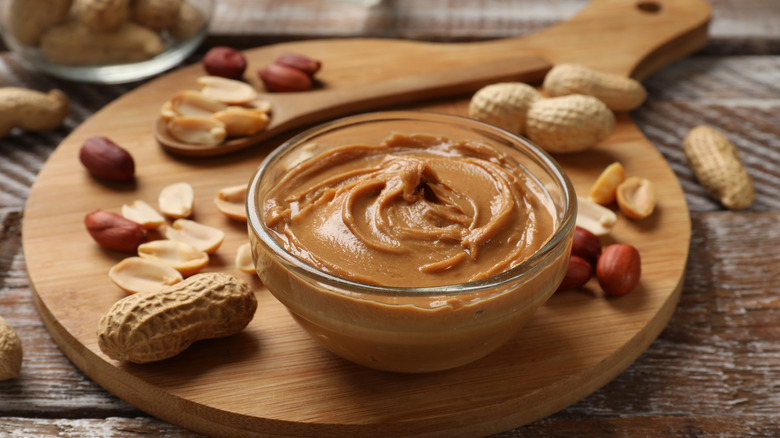 Peanut butter in bowl on wood board