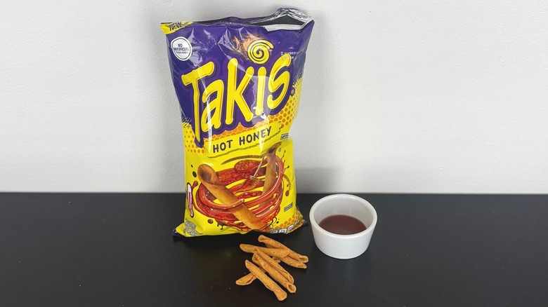 A bag of Hot Honey Takis with a bowl of hot honey