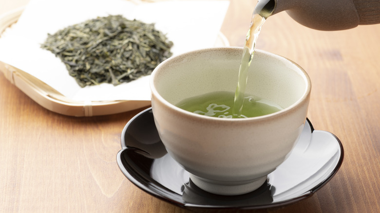 Pouring green tea into a cup