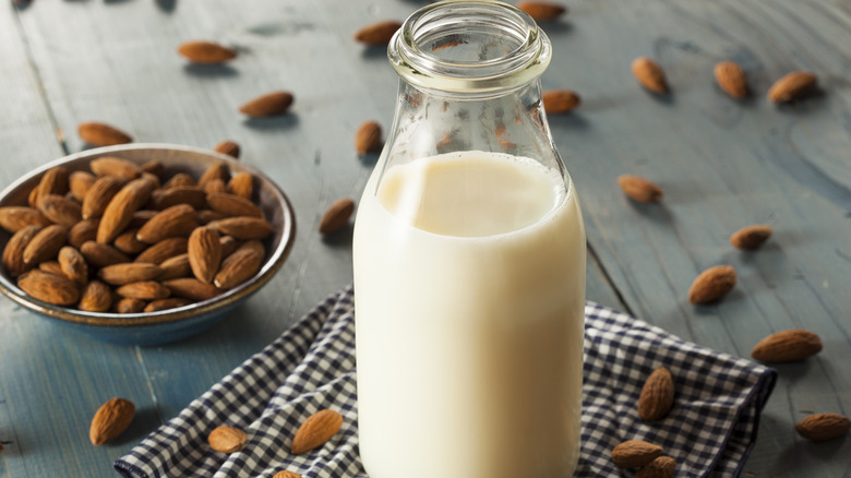 Almond milk with almonds in background