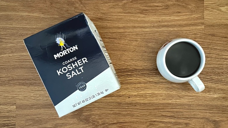 Box of kosher salt and white mug of coffee
