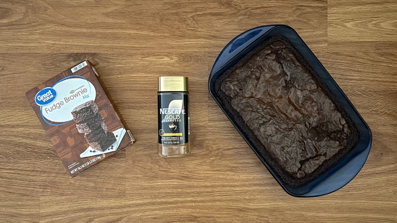 Box of Great Value Fudge Brownie Mix, jar of Nescafe Espresso powder, baked brownies in blue baking dish