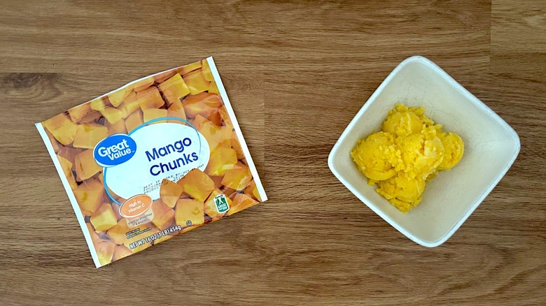 Frozen mango chunks and white bowl of mango ice cream