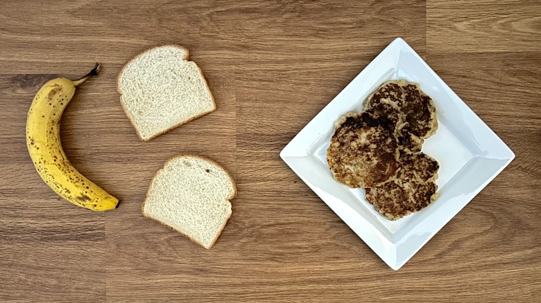 Banana, two slices of bread, pancakes on square white plate