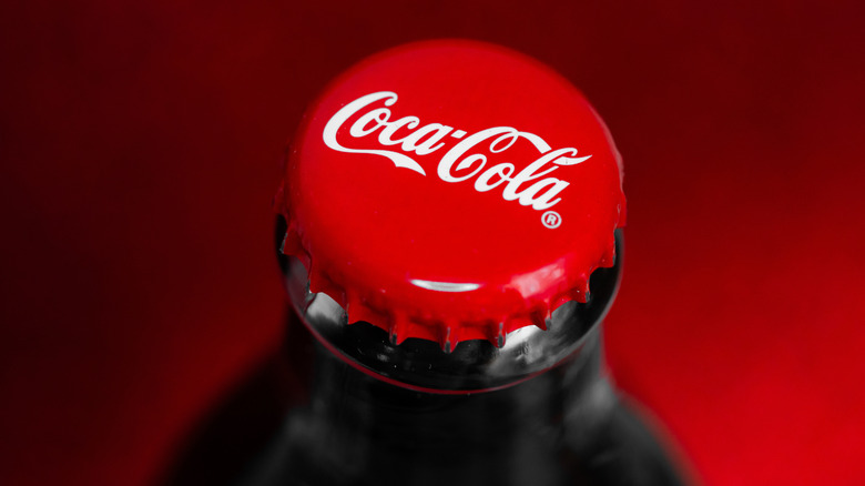 A close up of a Coca-Cola bottle and cap
