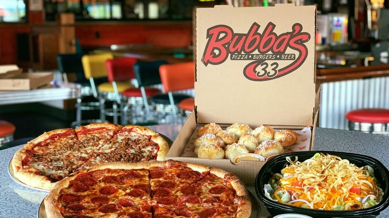 Bubba's 33 pizza breadsticks and salad on a table