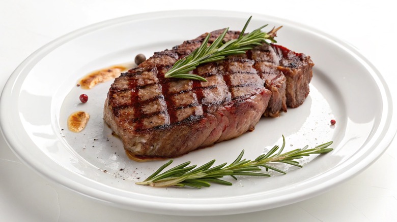 Grilled ribeye steak on a white plate