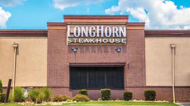 Exterior of a Longhorn Steakhouse against a bright blue sky with white clouds