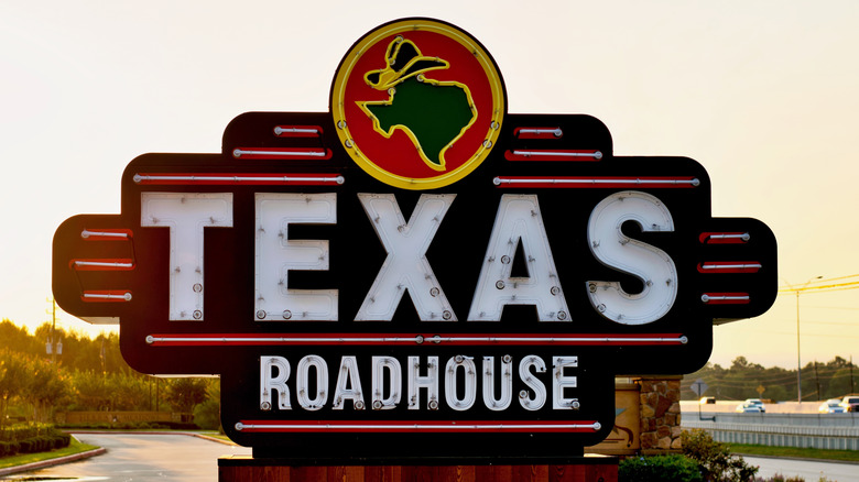 Texas Roadhouse sign with a highway in the background