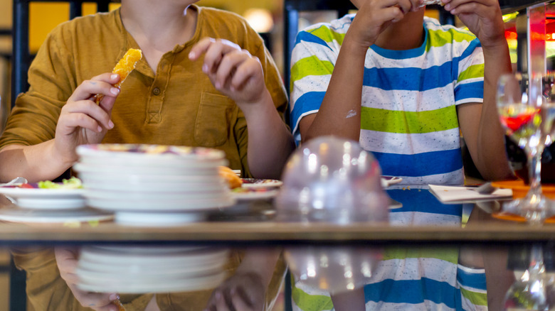 Two kids eating at a restaurant