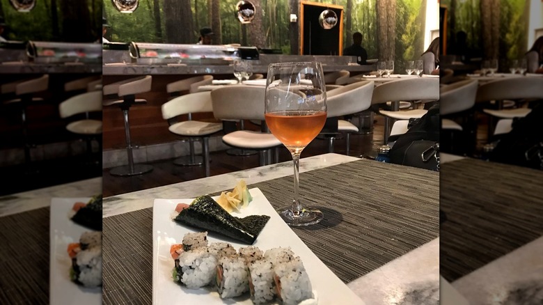 View of sushi and wineglass on table at One Flew South bar in Atlanta airport