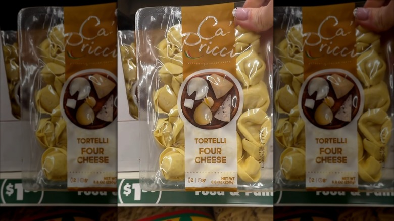 A hand holding a package of Ca' Pricci Tortellini Four Cheese