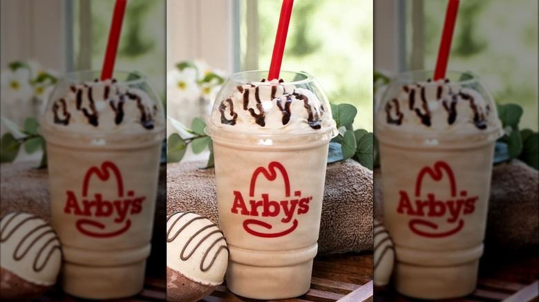 Arby's Jamocha shake in a plastic cup with whipped cream and chocolate drizzle on top