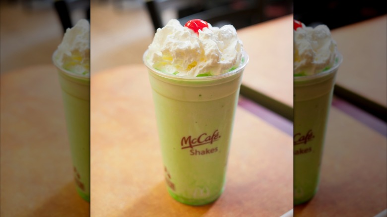 McDonald's Shamrock shake in a plastic cup with whipped cream and cherry on top