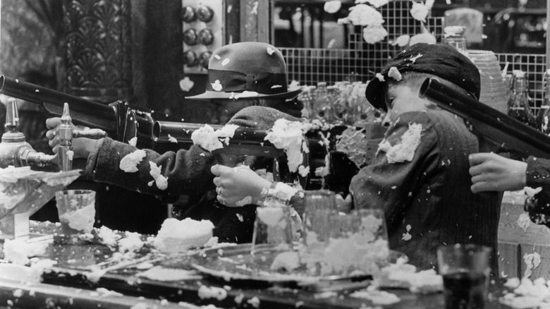 In a still from "Bugsy Malone," child actors dressed as gangsters fire cream guns