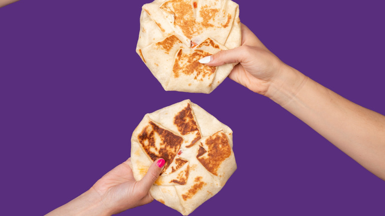 Hands holding crunchwrap supremes