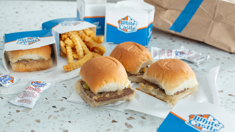 A table with four White Castle sliders and an order of fries