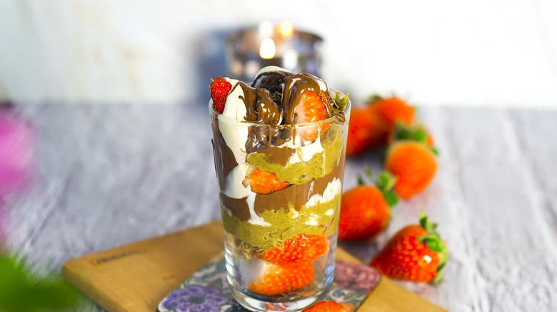 Dubai Strawberry Chocolate Cup on cutting board in front of fresh strawberries