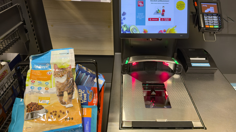 A self-checkout bagging area is stacked with items.