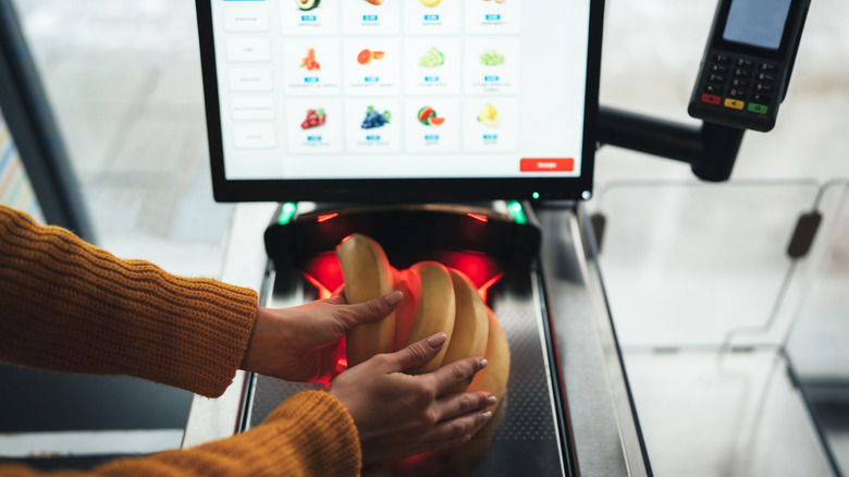A shopper scans bananas in a grocery store.