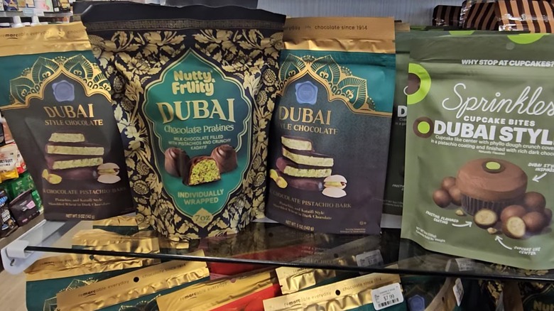 Dark green packages of Dubai chocolates on shelving